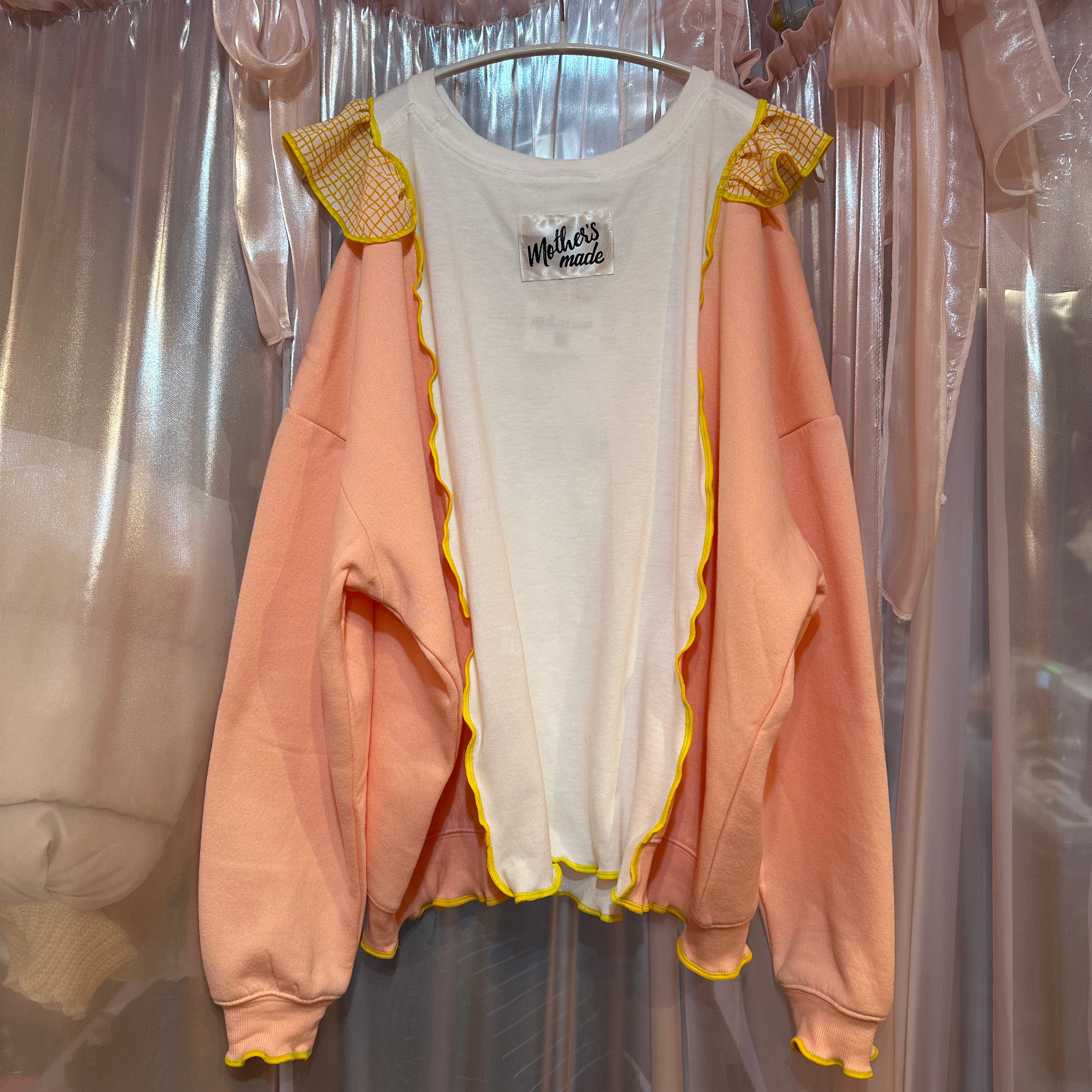 黄色のチェック柄とピンクの猫柄のスウェットシャツ